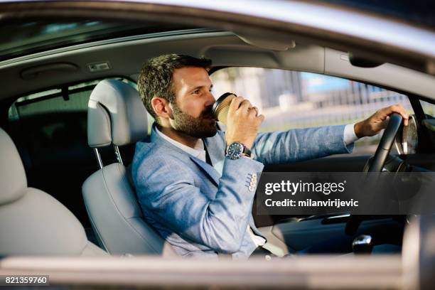 handsome man drinking coffee while driving - luxury baby car seat stock pictures, royalty-free photos & images