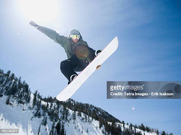man on snowboard in air, wasatch mountains, utah, united states - snowboard foto e immagini stock