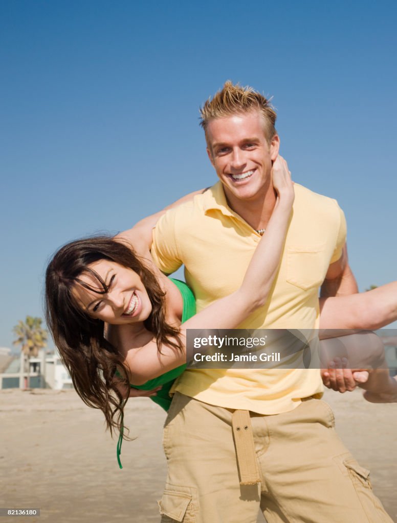 Man holding girlfriend behind back