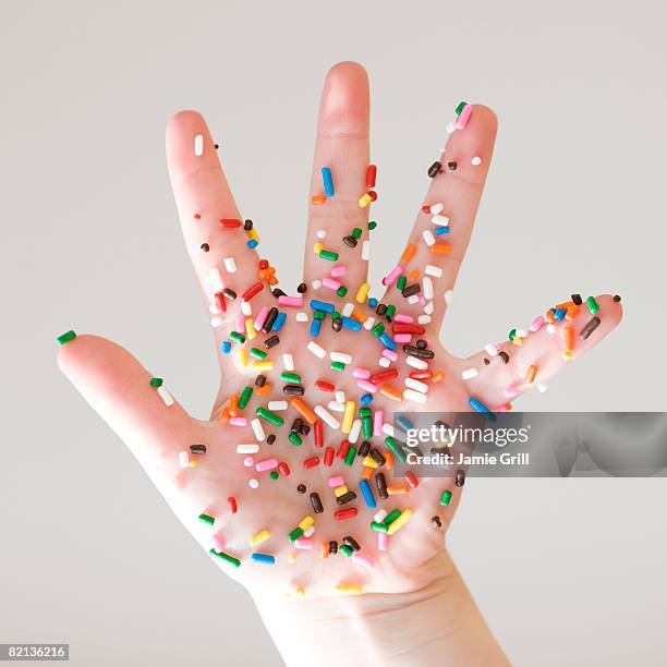 close up of sprinkles on child?s hand - sprinkles stock-fotos und bilder