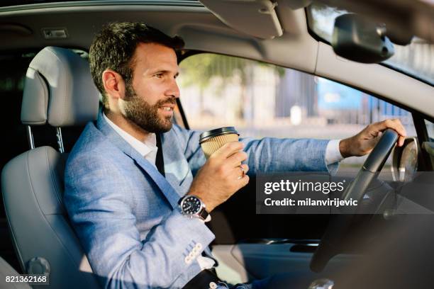 handsome busnessman driving a car and drinking coffee to go - coffee car design stock pictures, royalty-free photos & images