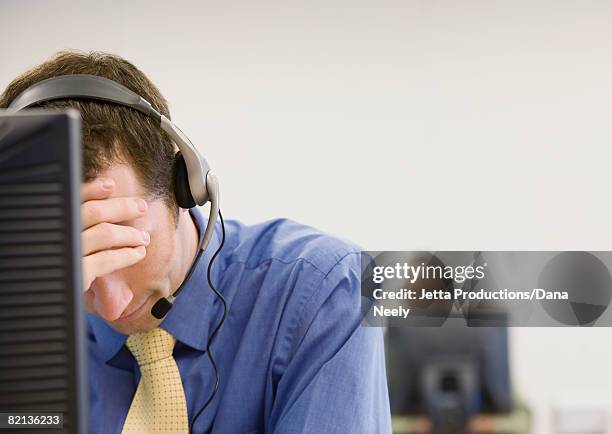 disappointed businessman wearing headset - overdoing stock pictures, royalty-free photos & images