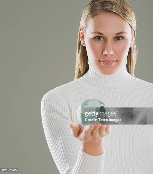 woman holding glass globe - world at your fingertips stockfoto's en -beelden