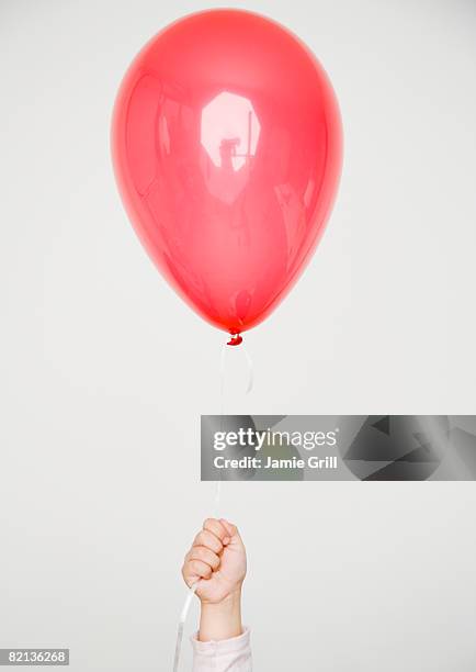 child holding red balloon - heliumballon stockfoto's en -beelden