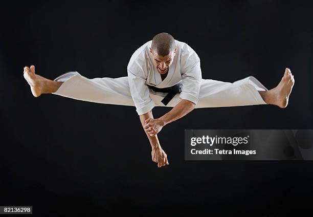 hispanic male karate black belt jumping in air - martial arts belt stock pictures, royalty-free photos & images