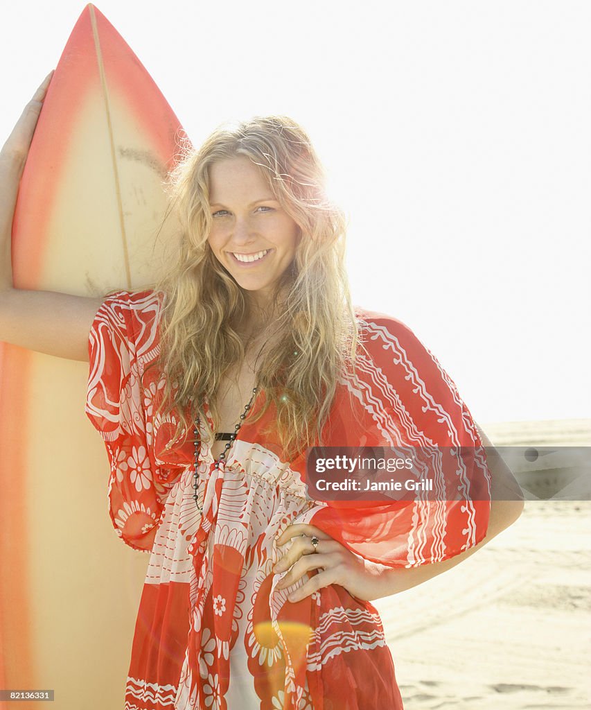 Woman holding surfboard on beach