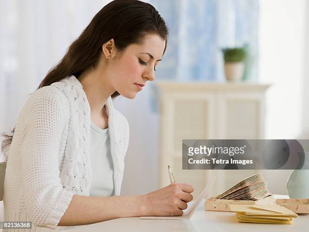 woman writing at table - thank you note stock pictures, royalty-free photos & images
