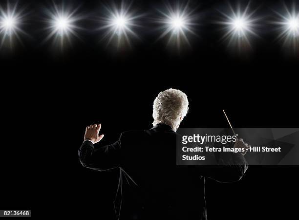 man in tuxedo conducting under lights - conductor ストックフォトと画像