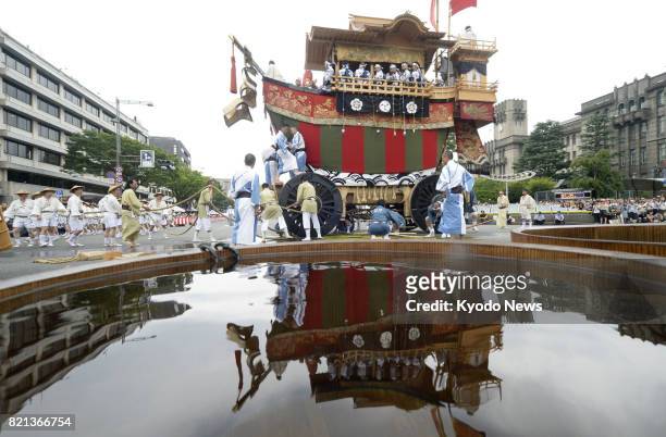 Photo taken July 24 shows "Ofunehoko," a ship-shaped decorated float, and its reflection on the water's surface during the Yamahoko parade of Kyoto's...