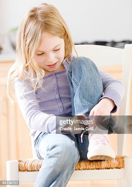 close up of girl tying shoe - schnürsenkel stock-fotos und bilder