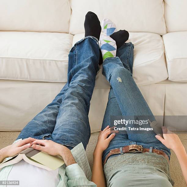 couple with feet up on sofa - playing footsie stock pictures, royalty-free photos & images