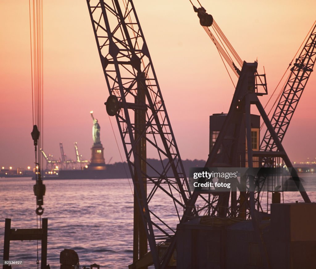 Crane with Statue of Liberty in background, New York, United States