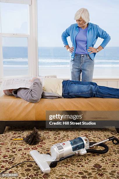 woman looking at man sleeping next to vacuum - lazy husband stock pictures, royalty-free photos & images