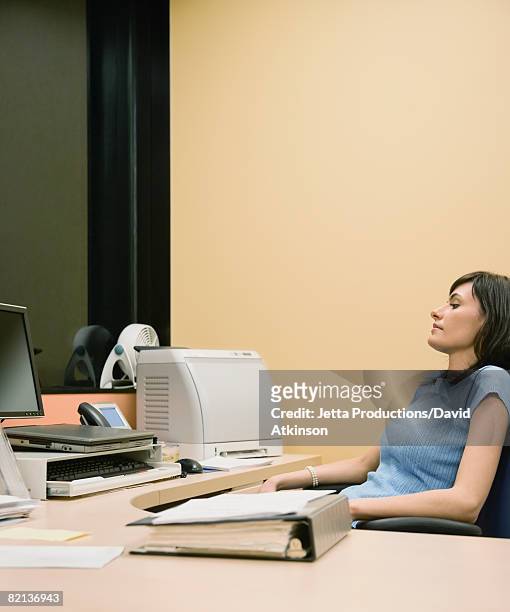 businesswoman sitting at desk - overdoing stock pictures, royalty-free photos & images