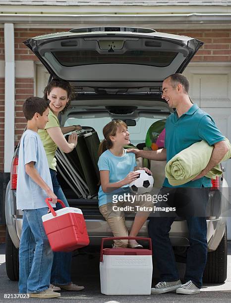 family packing car for vacation - soccer mum stock-fotos und bilder