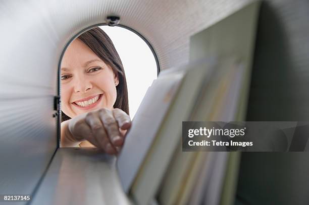 woman reaching into mailbox for mail - junk mail stock pictures, royalty-free photos & images