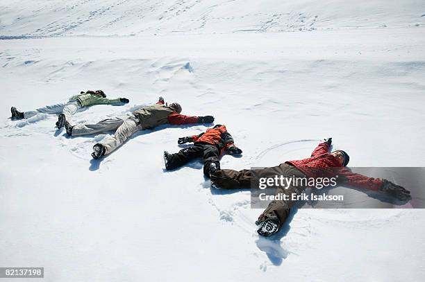 family making snow angels - family in snow mountain stockfoto's en -beelden