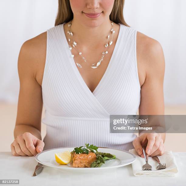 woman sitting at dinner table - formal dining stock pictures, royalty-free photos & images