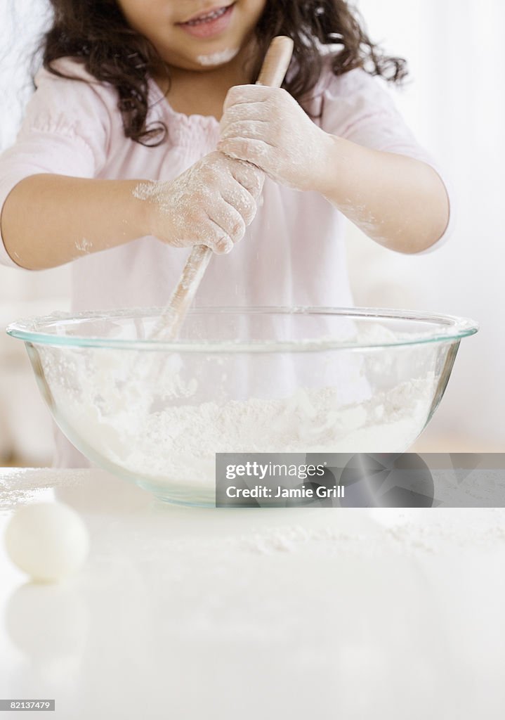 Hispanic girl mixing dough