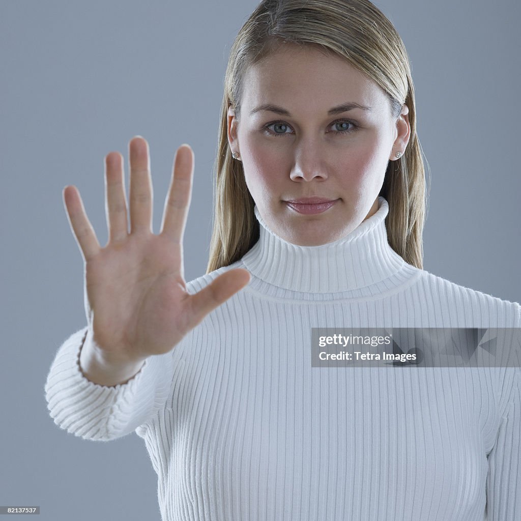 Woman holding up hand with palm out