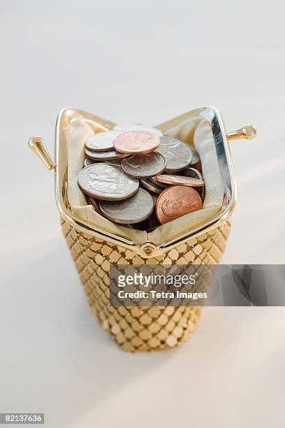 coins in open change purse - gold purse fotografías e imágenes de stock