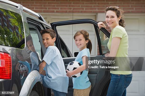 mother and children getting into car with soccer ball - soccer mom stock pictures, royalty-free photos & images