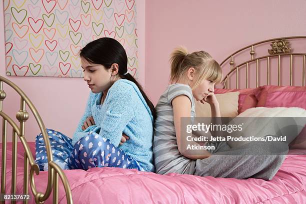 girl sitting back to back on bed - friends fighting stock pictures, royalty-free photos & images