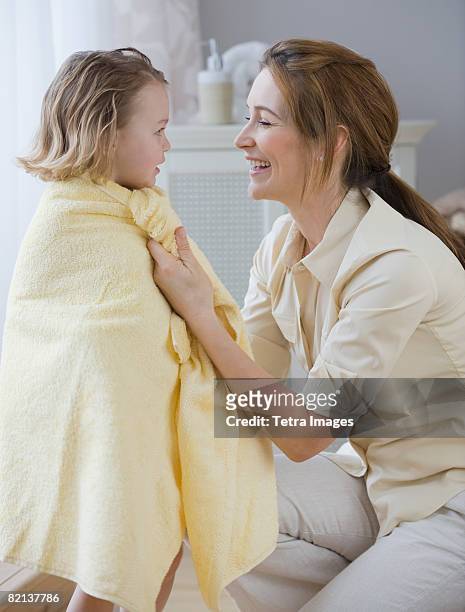 mother drying daughter with towel - mother daughter towel fotografías e imágenes de stock