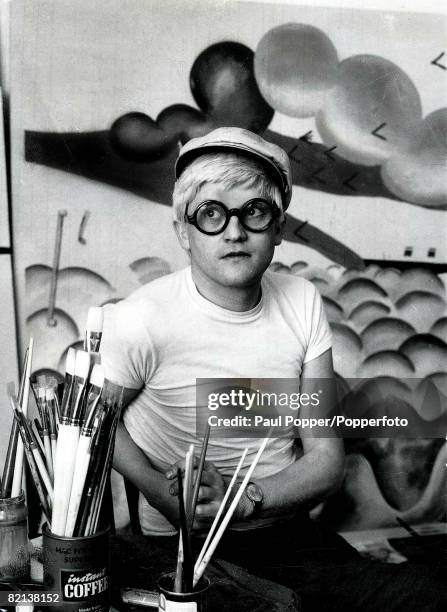 Volume 2, Page 115, Picture Artist, David Hockney, wearing his trade-mark hat and glasses, pictured in his studio, circa 1965.