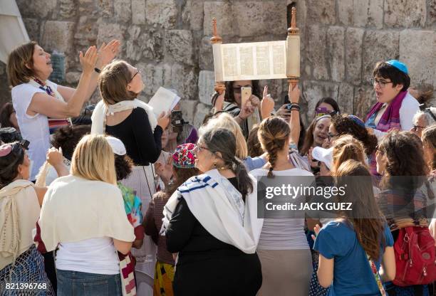 Members of the liberal Jewish religious group Women of the Wall hold up a Torah scroll as they pray at the Western Wall in Jerusalem's Old City on...