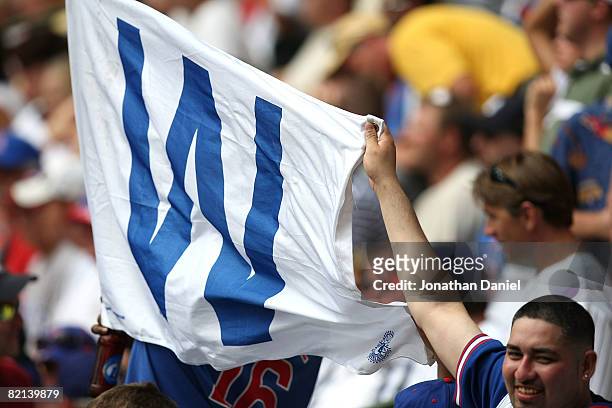Fans of the Chicago Cubs hold up a win flag in the outfield after the Cubs complete a four game sweep of the Milwaukee Brewers at Miller Park on July...
