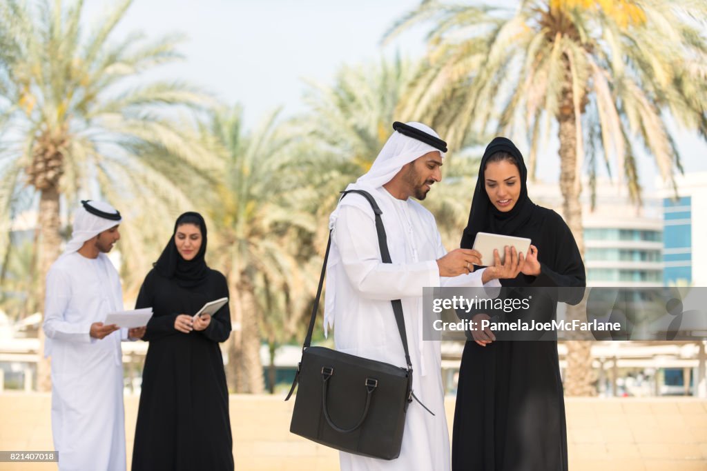 Arabische Unternehmerinnen, Unternehmer treffen außen mit Handy, Tablet, Laptop, Dokumente