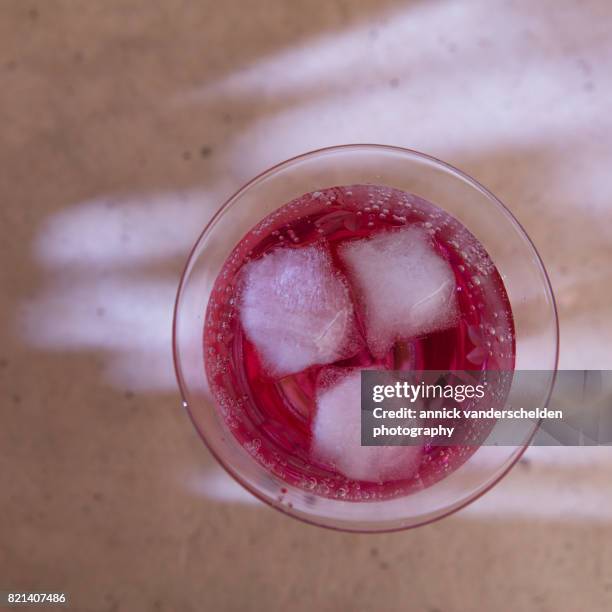 carbonated water with grenadine and ice cubes. - grenadine stock pictures, royalty-free photos & images