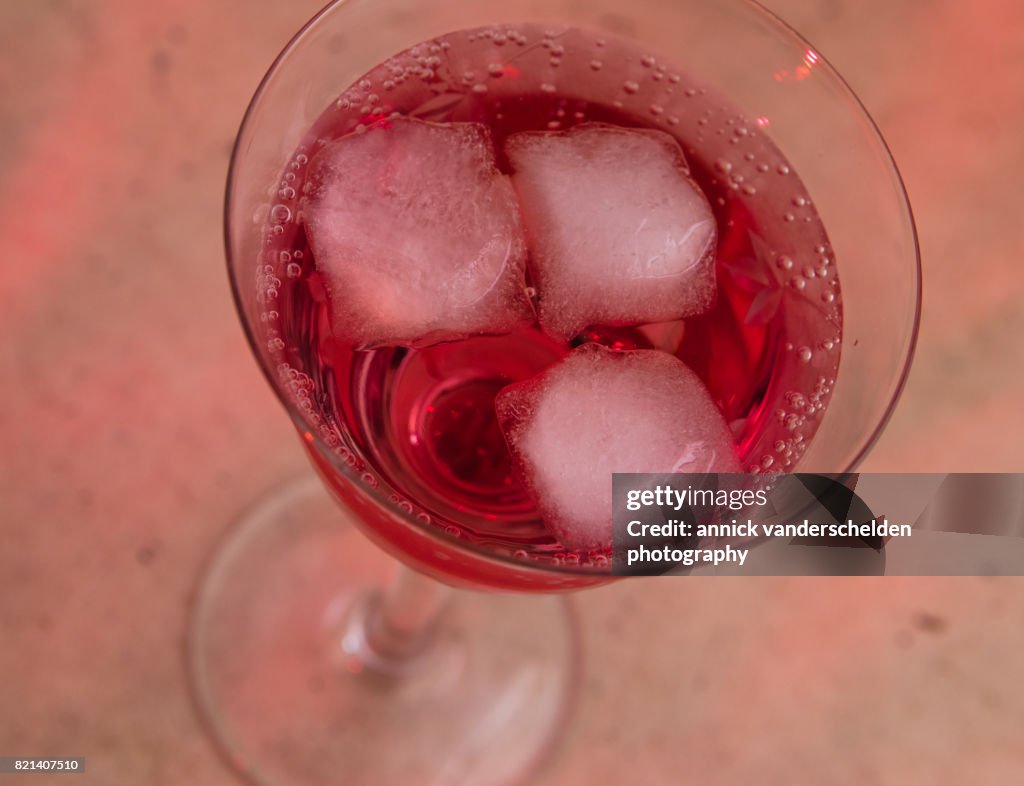 Carbonated water with grenadine and ice cubes.