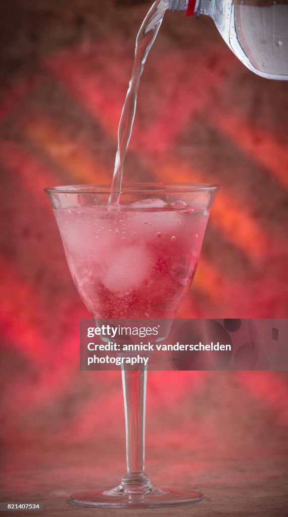 Carbonated water with grenadine and ice cubes.
