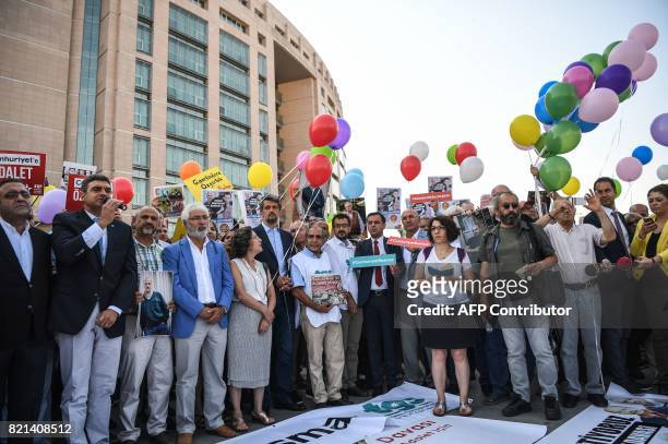 People and Journalists from daily opposition newspaper Cumhuriyet prepare to free colored air balloons as they shout slogans during a gathering on...