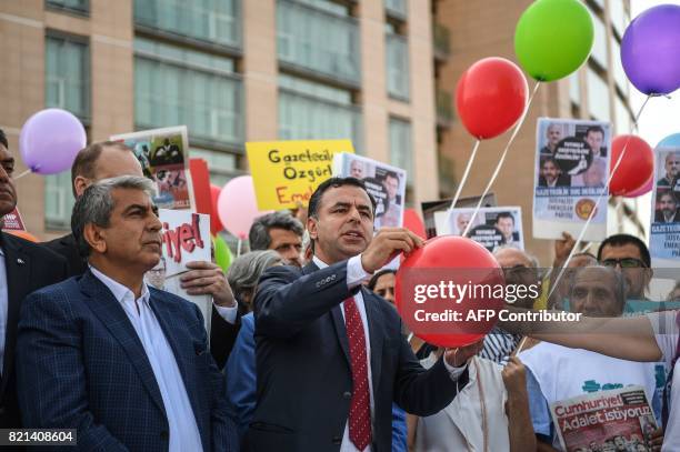 People and Journalists from daily opposition newspaper Cumhuriyet prepare to free colored air balloons as they shout slogans during a gathering on...