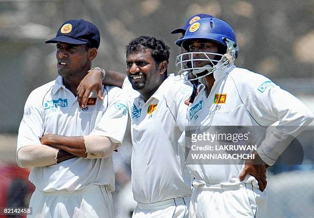 Sri Lankan cricketer Muttiah Muralitharan with teammates Thilan Samaraweera and Tillekeratne Dilshan wait for a decision from the third umpire for...