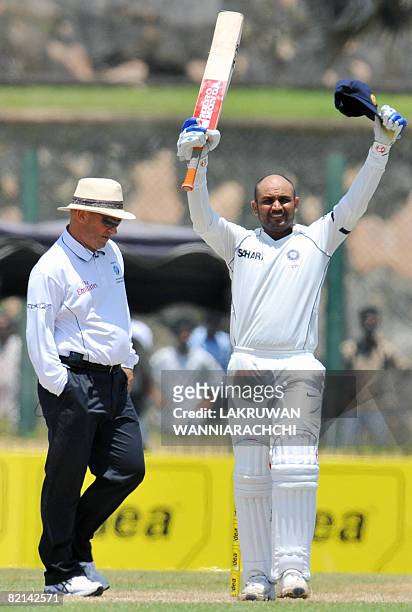 Indian cricketer Virender Sehwag raises his bat to the crowd after completing 200 runs during the second day of the second Test match between India...