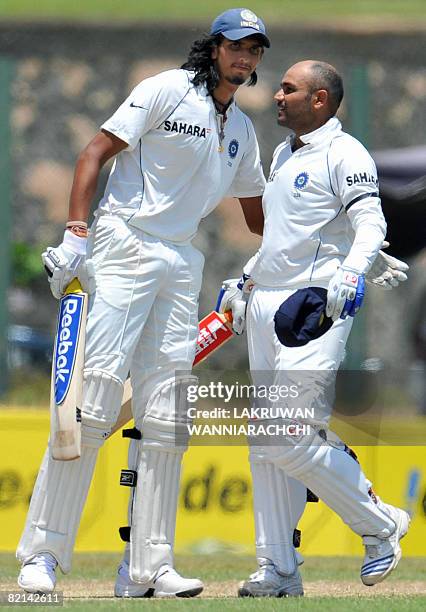 Indian cricketer Virender Sehwag is congratulated by teammate Ishant Sharma after completing a double century during the second day of the second...