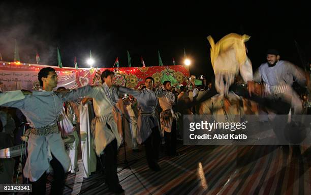 Traditional dancing band plays a popular piece of music while Palestinian grooms wearing traditional clothes, or Abaya, dance during a mass wedding...