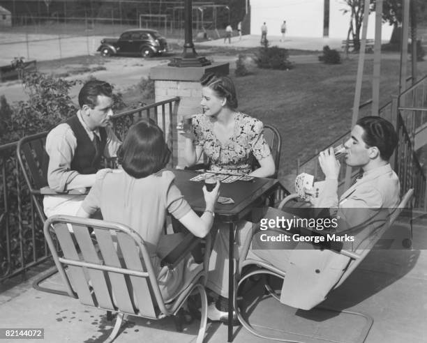 two couples playing cards and drinking on terrace , (b&w) - dating game stock pictures, royalty-free photos & images