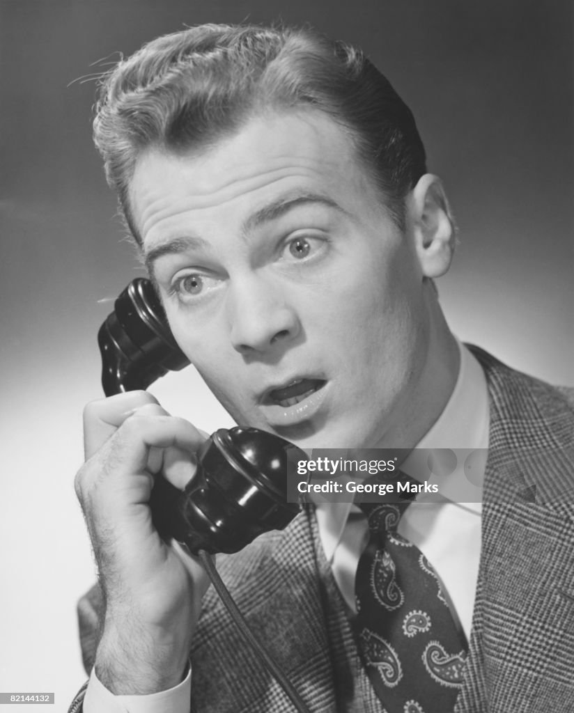 Man talking on phone in studio, (B&W)