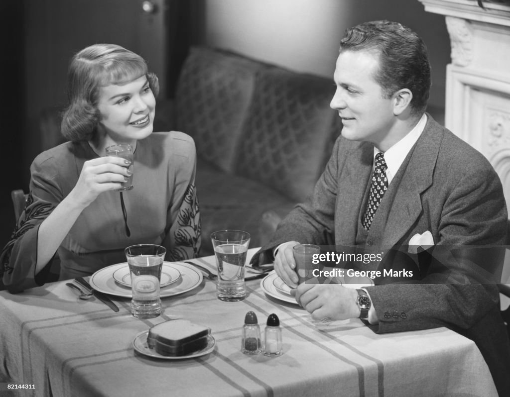 Couple having breakfast at table, (B&W)