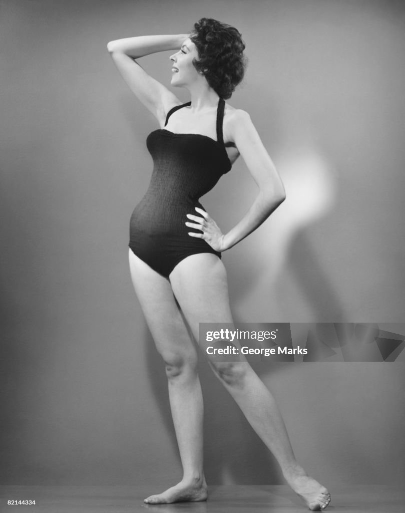 Woman in swimsuit posing in studio, (B&W)