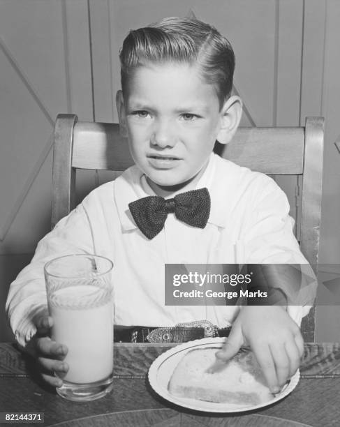 elegant boy (6-7) eating breakfast, (b&w) - pompadour stock pictures, royalty-free photos & images