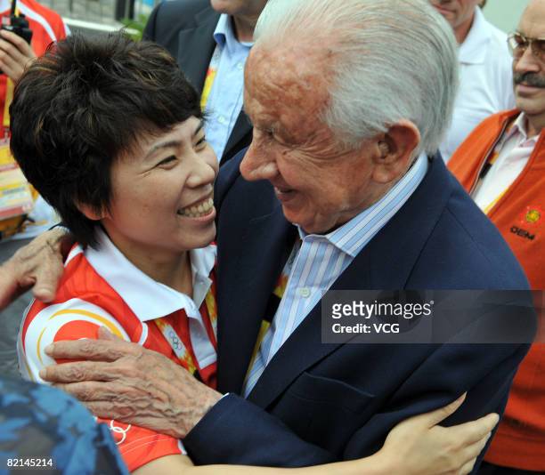 Honorary president Juan Antonio Samaranch hugs Deng Yaping, spokeswoman and deputy director of the Olympic Village department and former Olympic...