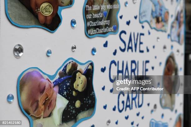 Picture shows a poster set up by supporters of the family of British baby Charlie Gard outside the Royal Courts of Justice in London on July 24, 2017...