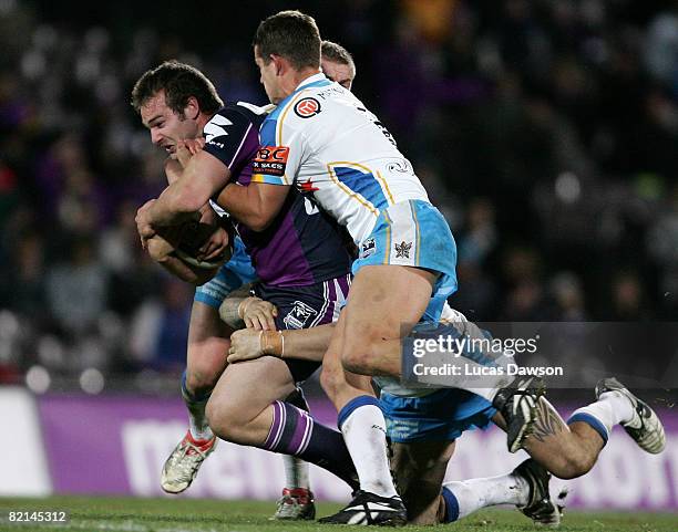 Scott Anderson of the Storm gets tackled by Titans players during the round 21 NRL match between the Melbourne Storm and the Gold Coast Titans at...