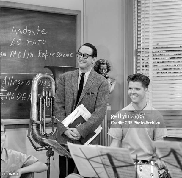 American actor William Schallert , as Mr. Leander Pomfritt, and an unidentified child actor smile together in a scene from the television series 'The...